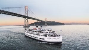 a boat sailing below the Golden Gate Bridge